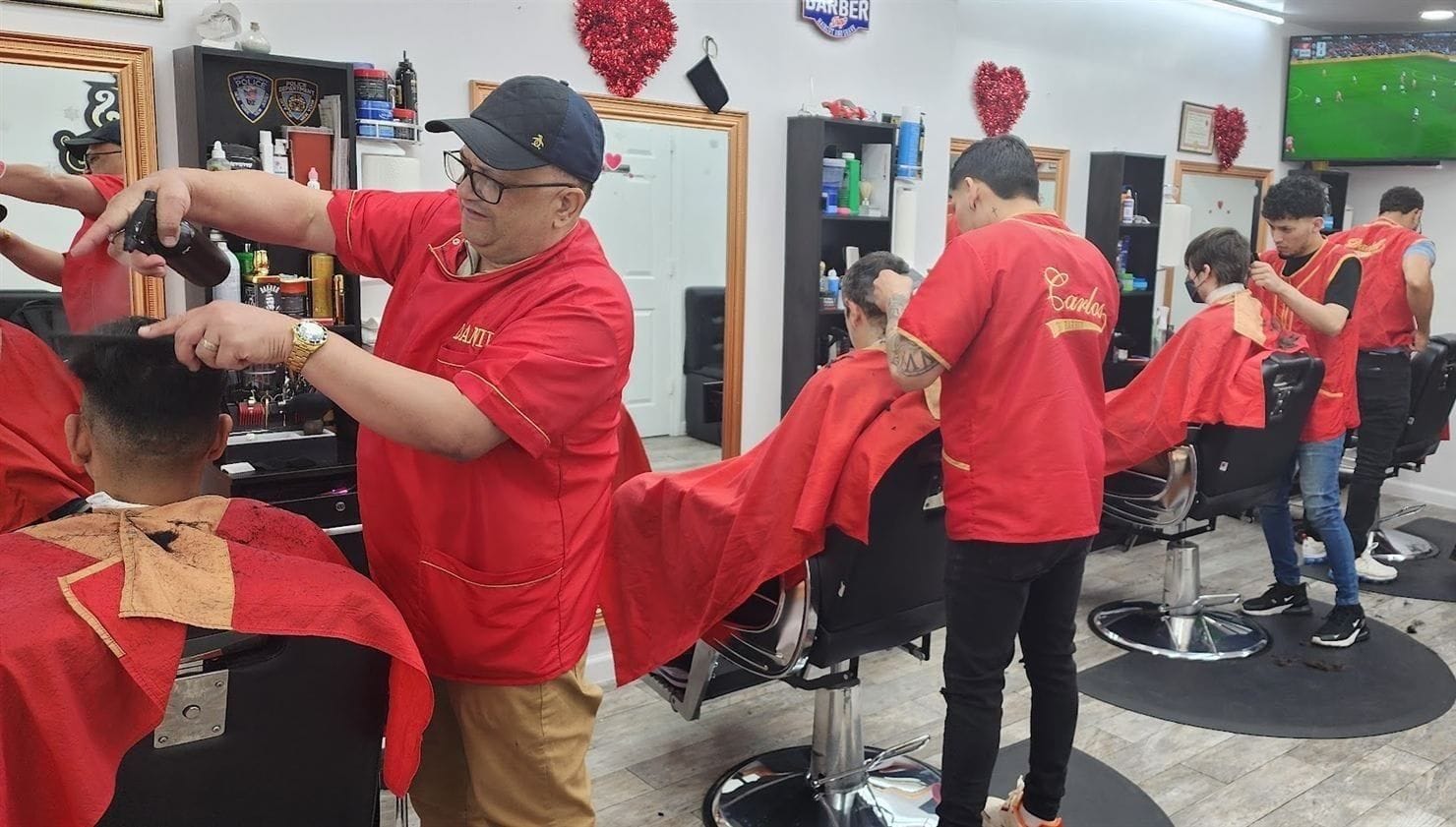 Daniel and his barbers in red vests working at their chairs